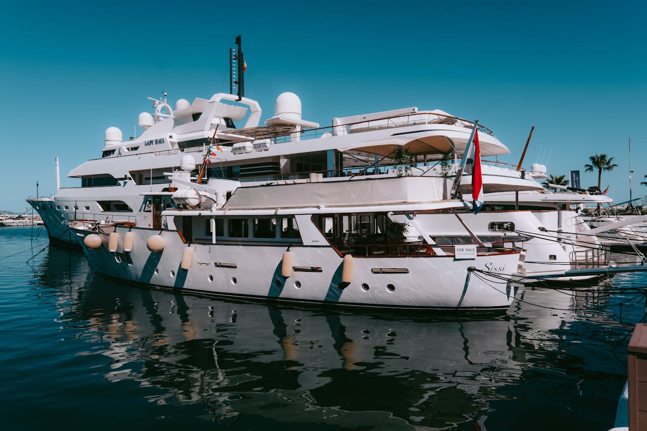 Elegant yachts docked at the picturesque Puerto Banus Marina under a clear blue sky.